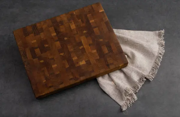 Walnut End Grain Cutting Board displayed on a grey stone table.